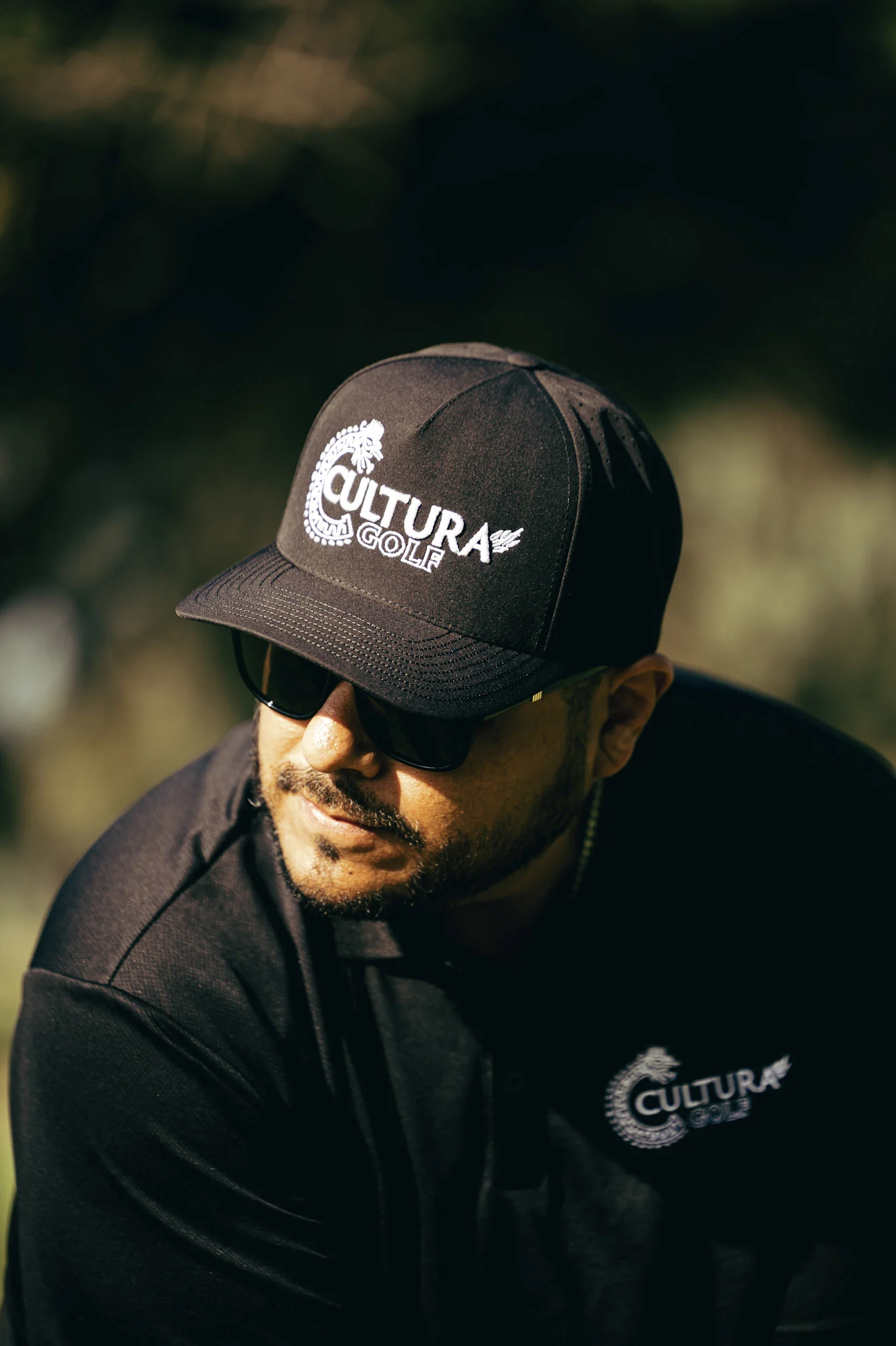 A Cultura Golf member in a branded cap and polo